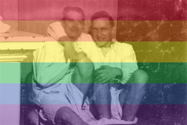 Två män håller armarna om varandra. Bilden går i prideflaggans färger.