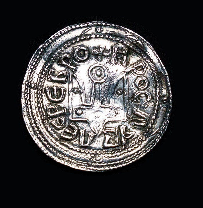 Ett silverfärgat mynt mot svart botten.