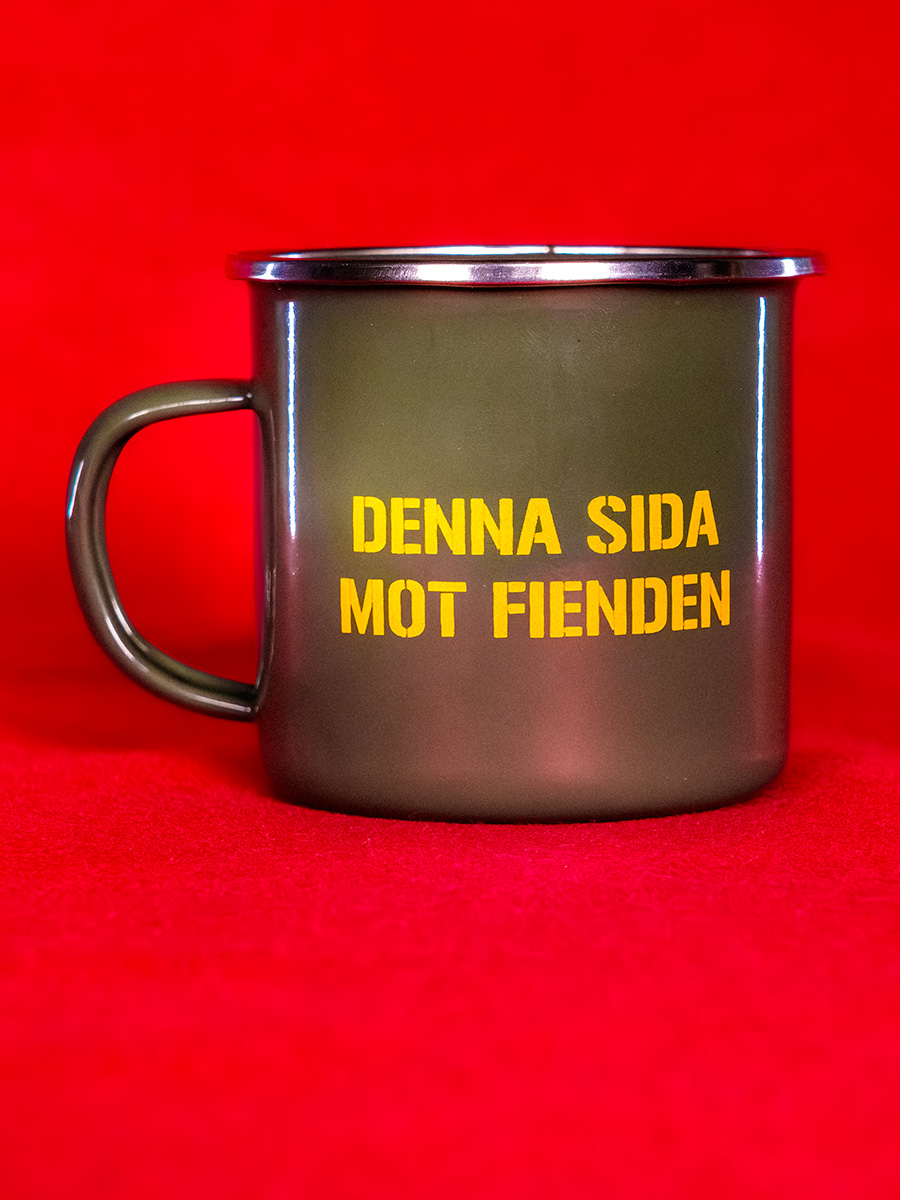 En gr&ouml;n emaljmugg med den gula texten "denna sidan mot fienden".