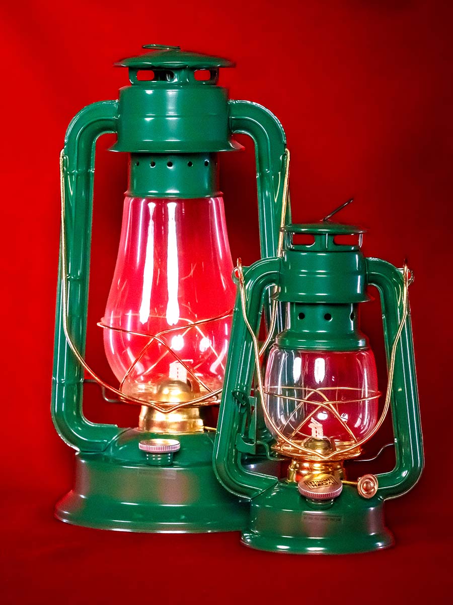 Tv&aring; olika stora gr&ouml;na fotogenlyktor mot r&ouml;d bakgrund.