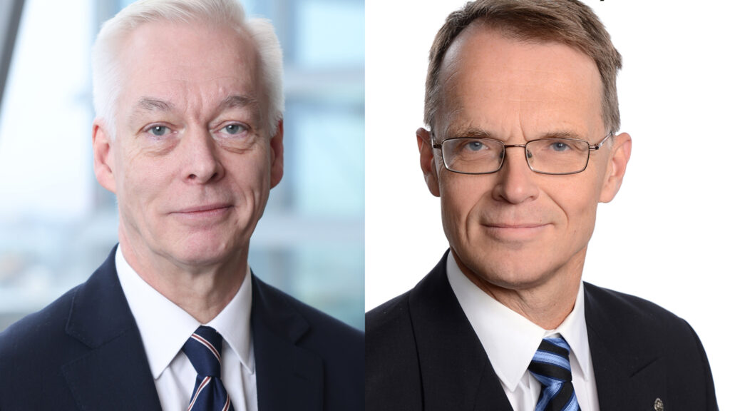 Två män i kostym och slips, tittar in i kameran.