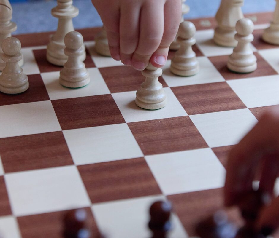 Tv&aring; barn som spelar schack i museimilj&ouml;.
